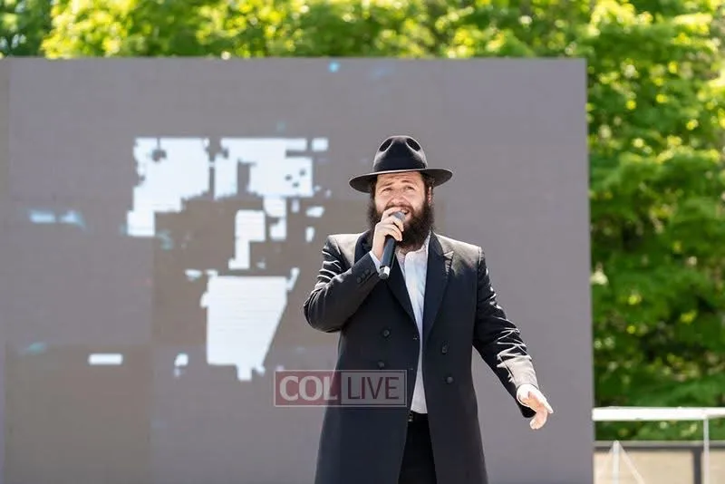 Motty on an outdoor stage at a community event